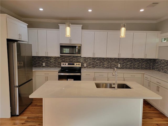 kitchen featuring backsplash, stainless steel appliances, a kitchen island with sink, and sink