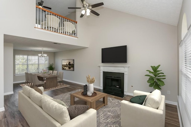 living area with a ceiling fan, a chandelier, baseboards, a fireplace with flush hearth, and wood finished floors