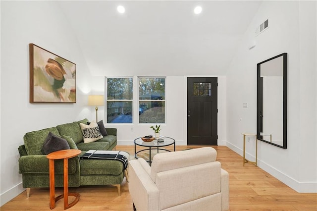 living room featuring light wood-type flooring and lofted ceiling