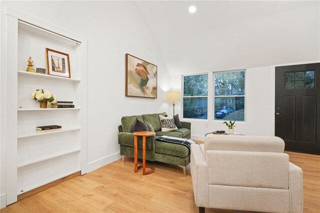 living area with wood-type flooring and vaulted ceiling