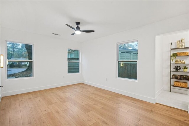 unfurnished room featuring a wealth of natural light, ceiling fan, and light hardwood / wood-style floors