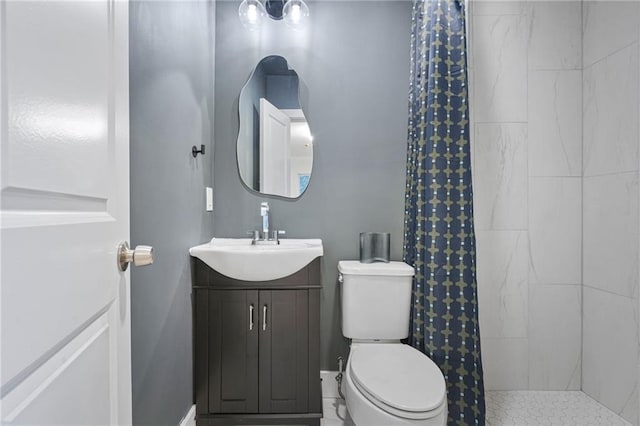 bathroom with toilet, vanity, and tiled shower