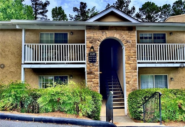 3120 Seven Pines Ct Unit 203, Atlanta, GA 30339 - view of front facade with stucco siding, stone siding, and a balcony