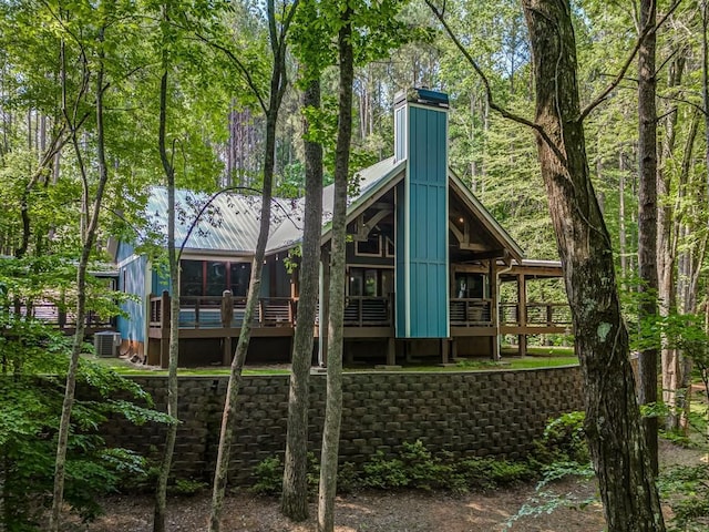 back of house featuring central AC unit and a deck