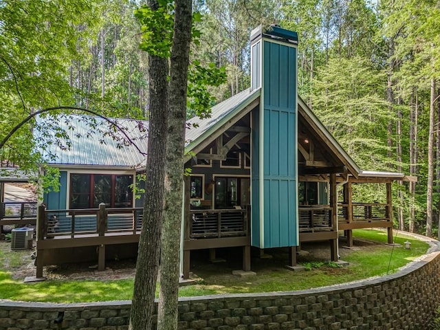 back of house featuring cooling unit and a wooden deck