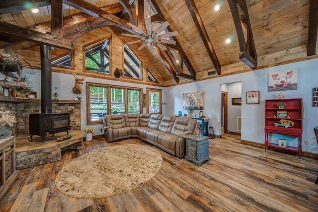 living room with a wood stove, wooden ceiling, beamed ceiling, high vaulted ceiling, and wood-type flooring