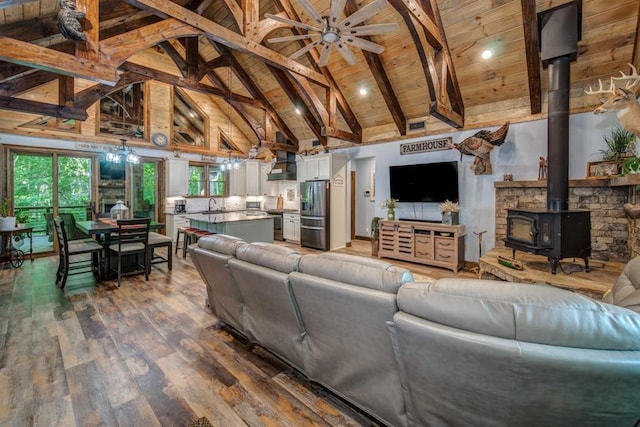 living room featuring a wood stove, wooden ceiling, beamed ceiling, high vaulted ceiling, and hardwood / wood-style floors