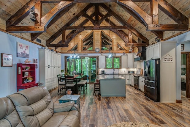 kitchen featuring beamed ceiling, a kitchen breakfast bar, a kitchen island, and stainless steel appliances