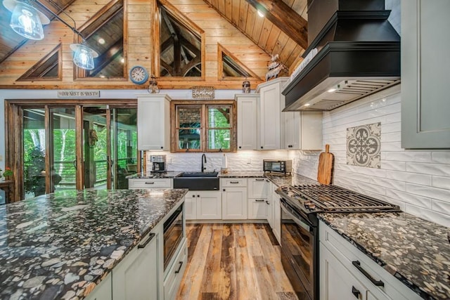 kitchen featuring stainless steel gas range oven, sink, wood ceiling, and premium range hood