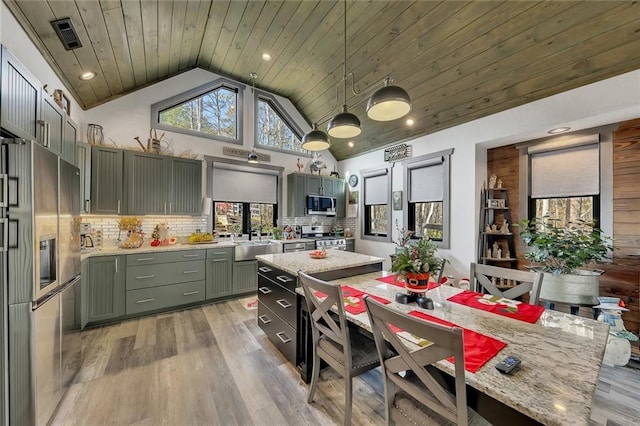 kitchen featuring wooden ceiling, hanging light fixtures, stainless steel appliances, backsplash, and light hardwood / wood-style floors