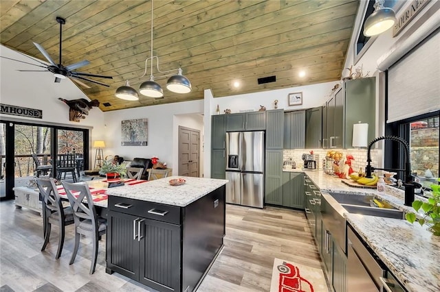 kitchen featuring stainless steel fridge, tasteful backsplash, wood ceiling, pendant lighting, and a center island