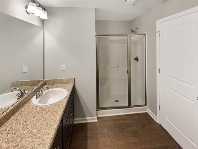 bathroom with vanity, wood-type flooring, and a shower with shower door