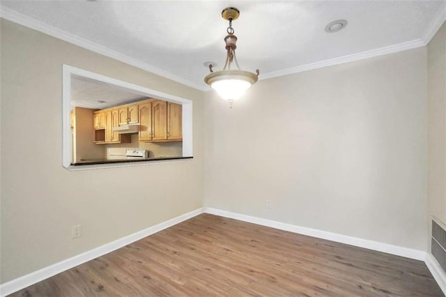 unfurnished dining area featuring ornamental molding, wood finished floors, and baseboards