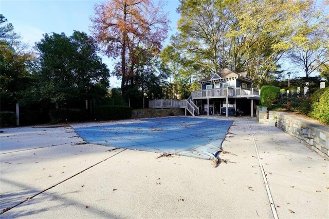 view of swimming pool featuring stairs, a patio area, a covered pool, and a wooden deck