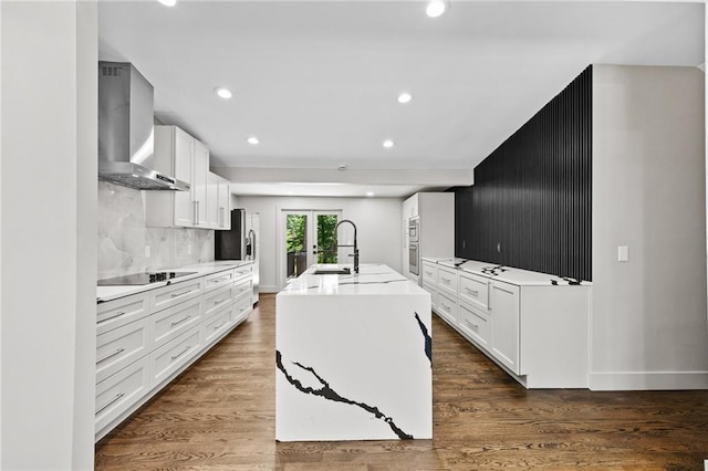 1887 Shalimar Dr, Atlanta, GA 30345 - kitchen with wall chimney exhaust hood, white cabinets, an island with sink, recessed lighting, and french doors