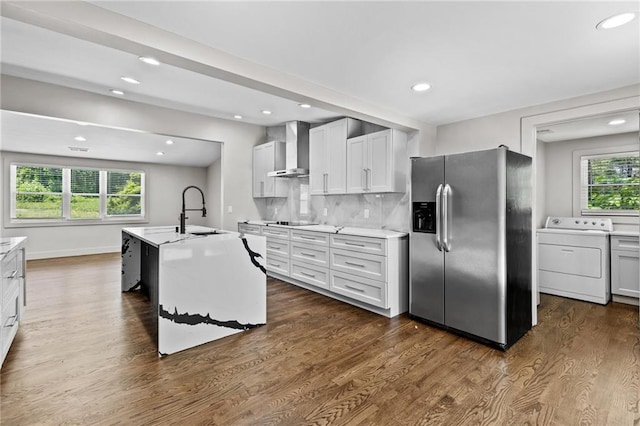 1887 Shalimar Dr, Atlanta, GA 30345 - kitchen featuring washer / dryer, stainless steel fridge, wall chimney exhaust hood, black electric cooktop, and dark wood-style floors
