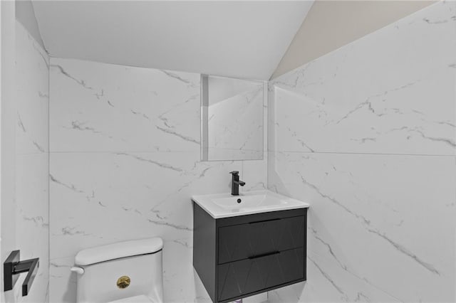 1887 Shalimar Dr, Atlanta, GA 30345 - bathroom with vanity, toilet, marble finish floors, tile walls, and lofted ceiling