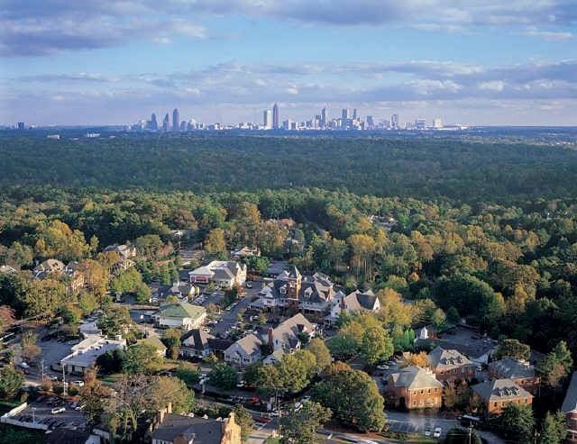 bird's eye view with a city view and a wooded view