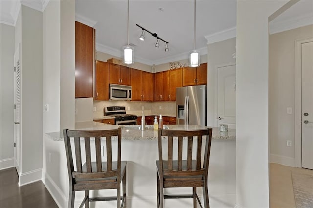 kitchen with ornamental molding, backsplash, stainless steel appliances, a peninsula, and hanging light fixtures