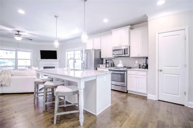 1420 Baygreen Rd, Suwanee, GA 30024 - kitchen with appliances with stainless steel finishes, a sink, a kitchen breakfast bar, ornamental molding, and white cabinets