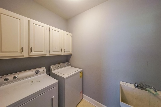 washroom with light tile patterned floors, cabinets, washer and clothes dryer, and sink