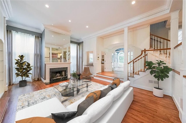 living room featuring crown molding, a healthy amount of sunlight, and hardwood / wood-style floors