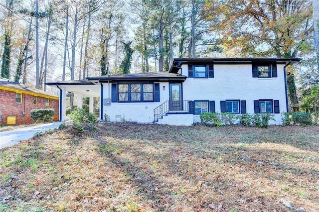 tri-level home featuring a carport and a front yard