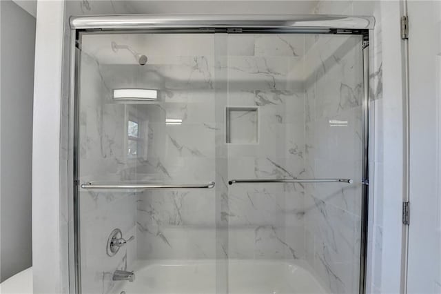 bathroom with shower / bath combination with glass door