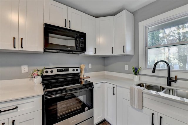 kitchen with white cabinetry, electric stove, and sink