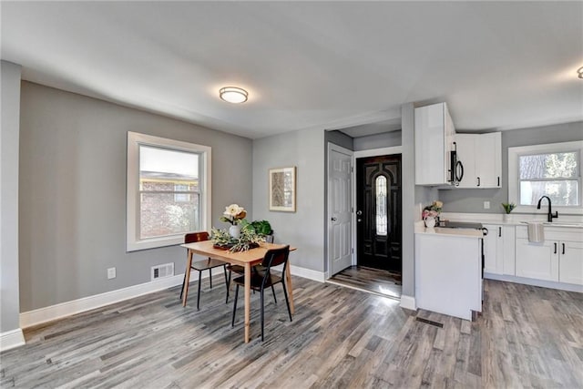 dining room featuring sink and light wood-type flooring