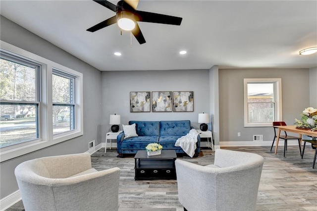 living room featuring wood-type flooring and ceiling fan