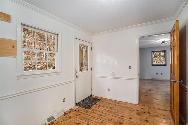 foyer with hardwood / wood-style floors and crown molding