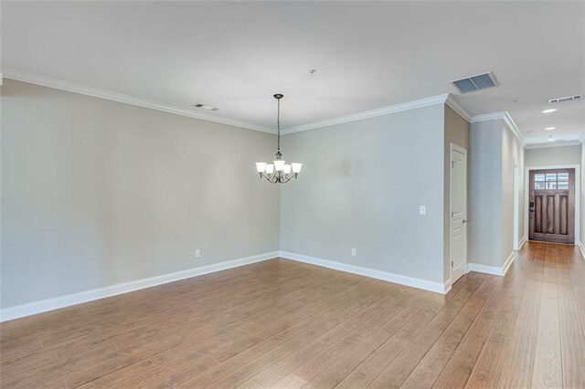 unfurnished room featuring an inviting chandelier, light wood-type flooring, and crown molding