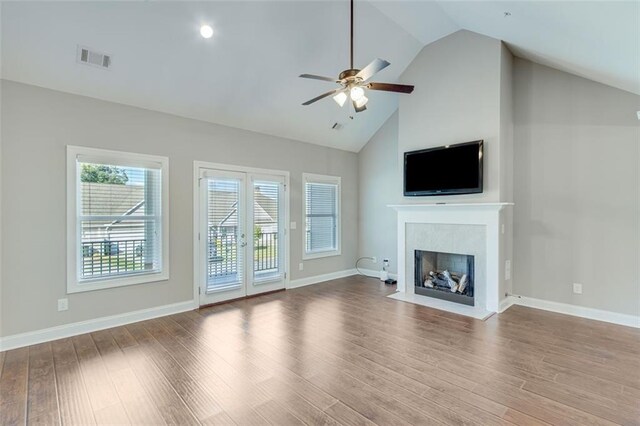 unfurnished living room with ceiling fan, french doors, light hardwood / wood-style floors, and high vaulted ceiling