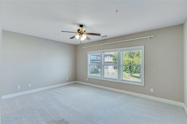 spare room with ceiling fan and light colored carpet