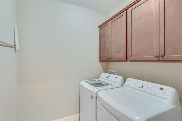 washroom featuring separate washer and dryer and cabinets