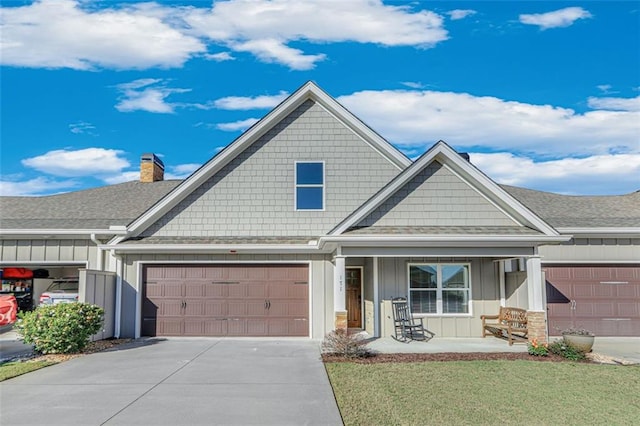 craftsman-style house featuring a front lawn, covered porch, and a garage