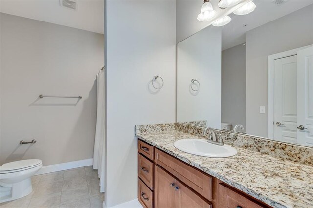 bathroom featuring tile patterned flooring, vanity, and toilet