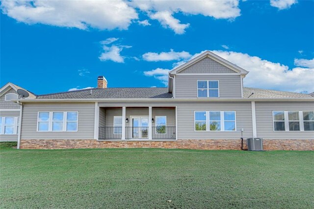 back of property with a yard and central AC unit