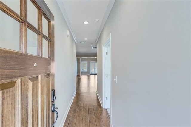 corridor featuring wood-type flooring and ornamental molding