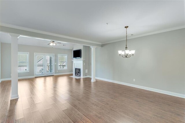 unfurnished living room featuring ornamental molding, ceiling fan with notable chandelier, and hardwood / wood-style floors