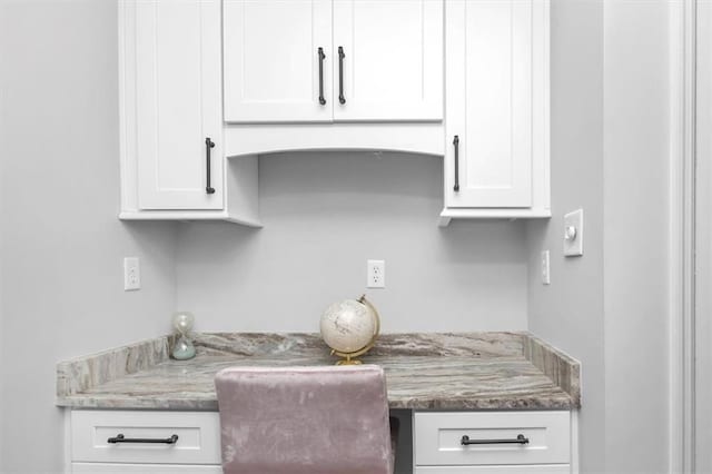 kitchen featuring white cabinets and light stone counters