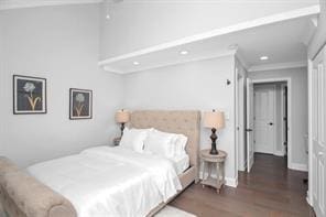 bedroom with dark hardwood / wood-style flooring and crown molding