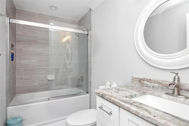 full bathroom with toilet, vanity, and shower / bath combination with glass door