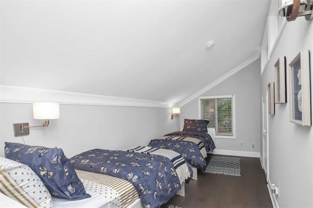 bedroom with vaulted ceiling, dark hardwood / wood-style flooring, and ornamental molding