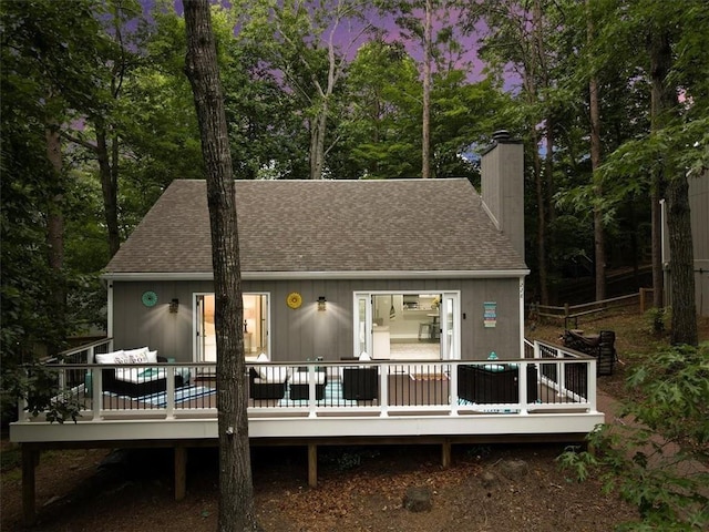 back house at dusk with a deck