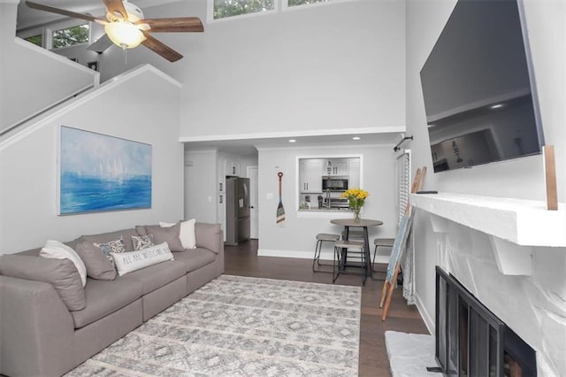 living room with ceiling fan, a healthy amount of sunlight, and dark wood-type flooring