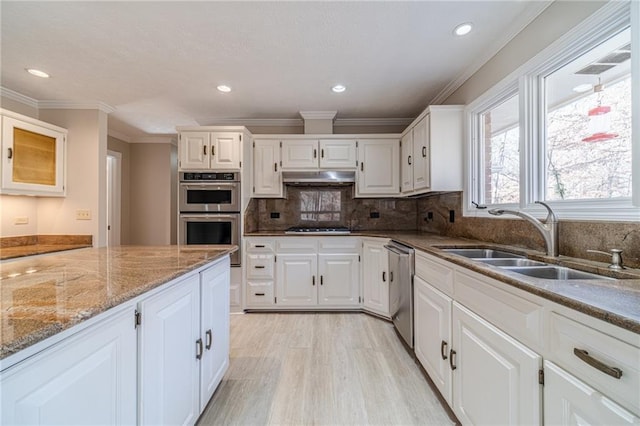 kitchen featuring tasteful backsplash, sink, white cabinets, light stone counters, and stainless steel appliances