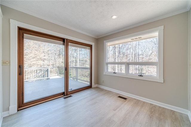 interior space featuring ornamental molding, a textured ceiling, and light wood-type flooring