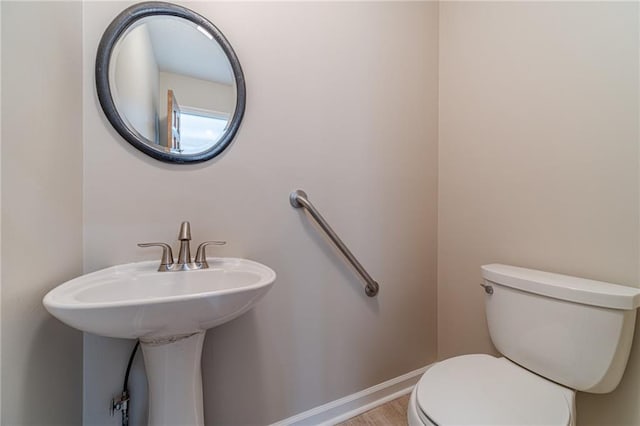 bathroom featuring hardwood / wood-style floors and toilet